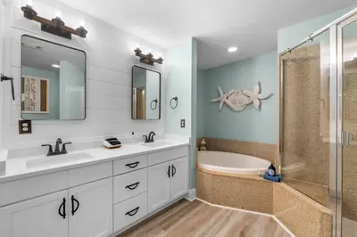 a bathroom with two sinks and a shower at Coast is Clear at Laketown Wharf #1225 by Nautical Properties in Panama City Beach