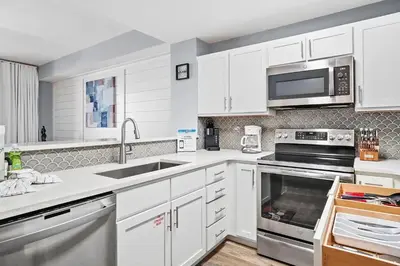 a white kitchen with a sink and a microwave at Calypso 3-2210 - Love Nest in Panama City Beach