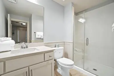 a white bathroom with a toilet and a shower at Calypso 3-2210 - Love Nest in Panama City Beach
