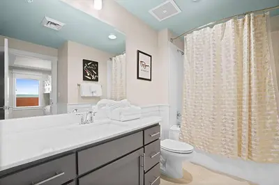a white bathroom with a sink and a toilet at Calypso 3-1601 - Corine's Corner in Panama City Beach
