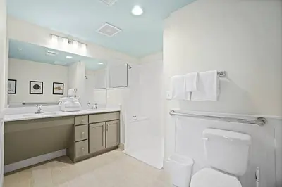a white bathroom with a toilet and a sink at Calypso 3-1601 - Corine's Corner in Panama City Beach