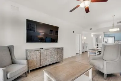 a living room with two chairs and a ceiling fan at Calypso 3-1511 in Panama City Beach