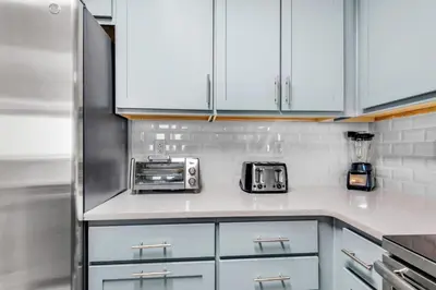 a kitchen with white cabinets and a refrigerator at Calypso 3-1511 in Panama City Beach