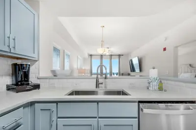 a kitchen with white cabinets and a sink at Calypso 3-1511 in Panama City Beach