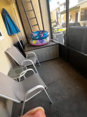 a group of chairs and an umbrella on a balcony at Sea & sand in Panama City Beach