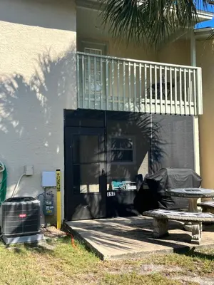a porch of a house with a table and a balcony at Sea & sand in Panama City Beach