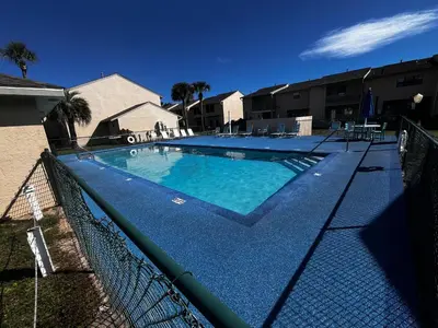a large swimming pool with a fence around it at Sea & sand in Panama City Beach