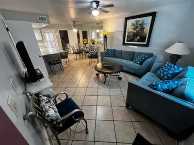 a living room with two blue couches and a table at Sea & sand in Panama City Beach