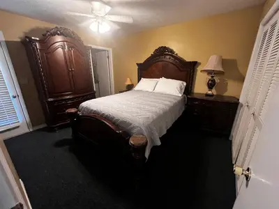 a bedroom with a large bed with a wooden headboard at Sea & sand in Panama City Beach