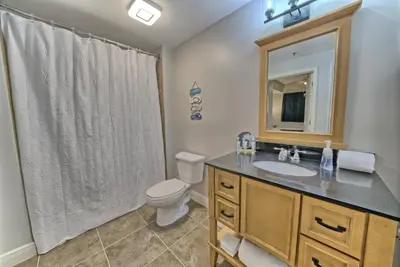 a bathroom with a toilet and a sink and a mirror at OCEAN FRONT CONDO w INCREDIBLE VIEWS in Panama City Beach