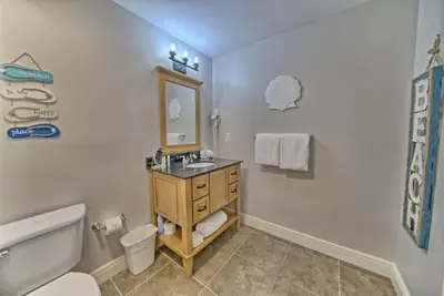 a bathroom with a sink and a toilet and a mirror at OCEAN FRONT CONDO w INCREDIBLE VIEWS in Panama City Beach