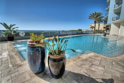 a swimming pool with two large pots with plants in it at OCEAN FRONT CONDO w INCREDIBLE VIEWS in Panama City Beach