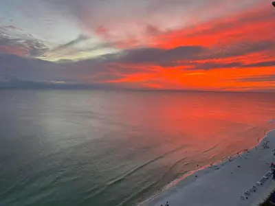 a sunset over the ocean with people on the beach at OCEAN FRONT CONDO w INCREDIBLE VIEWS in Panama City Beach