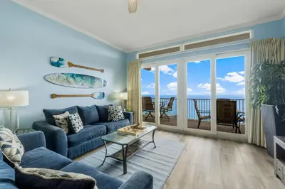 a living room with a blue couch and a view of the ocean at Penthouse Perfection at Laketown Wharf #2127 by Nautical Properties in Panama City Beach