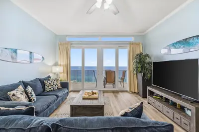 a living room with a blue couch and a flat screen tv at Penthouse Perfection at Laketown Wharf #2127 by Nautical Properties in Panama City Beach