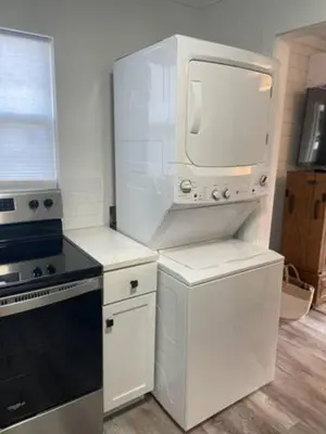 a white kitchen with a stove and a microwave at The Coastal Cabana in Panama City Beach