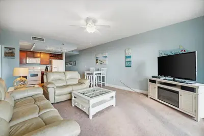 a living room with a couch and a flat screen tv at The Beach Scene at Laketown Wharf #524 by Nautical Properties in Panama City Beach