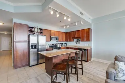 a kitchen with wooden cabinets and a stainless steel refrigerator at Laketown Wharf 2018 in Panama City Beach
