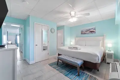 a bedroom with a bed and a blue wall at Slice o’ Paradise - Gulf Front! Walk to Pier Park in Panama City Beach