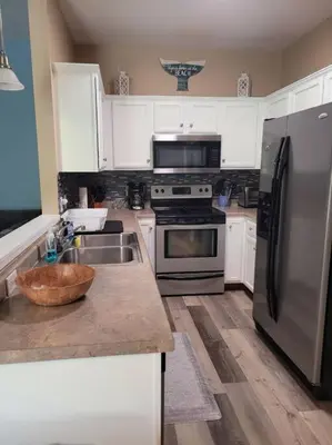 a kitchen with a stainless steel refrigerator and a sink at McDrifty's Getaway in Panama City Beach