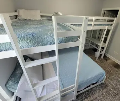 two white bunk beds in a room with a bed at McDrifty's Getaway in Panama City Beach