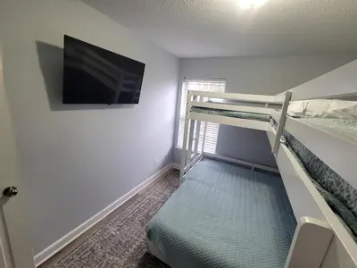 a room with two bunk beds and a flat screen tv at McDrifty's Getaway in Panama City Beach