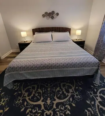 a bedroom with a bed with two lamps on two tables at McDrifty's Getaway in Panama City Beach