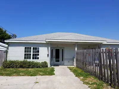 a white house with a fence in front of it at McDrifty's Hideaway in Panama City Beach
