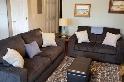 a living room with two couches and a table at McDrifty's Hideaway in Panama City Beach