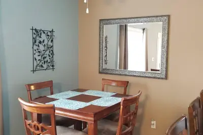 a dining room table with chairs and a mirror at McDrifty's Hideaway in Panama City Beach