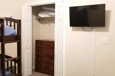 a bedroom with a tv on a wall with a closet at McDrifty's Hideaway in Panama City Beach
