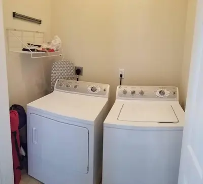 a laundry room with a stove and a washer and dryer at McDrifty's Hideaway in Panama City Beach