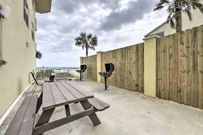 a wooden picnic table on a patio near a fence at Balcony and Beach Access Oceanfront PCB Condo in Panama City Beach