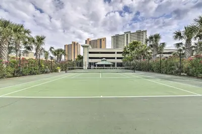 a tennis court in front of a building at Balcony and Beach Access Oceanfront PCB Condo in Panama City Beach