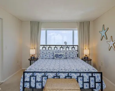 a bedroom with a blue and white bed with stars on the wall at Dunes of Panama Resort in Panama City Beach