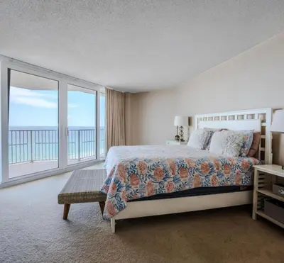 a bedroom with a bed and a view of the ocean at Dunes of Panama Resort in Panama City Beach