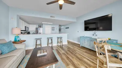 a living room with a couch and a kitchen at Beachfront Condo #1413 Majestic Beach Resort in Panama City Beach