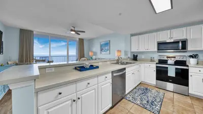 a kitchen with white cabinets and a view of the ocean at Beachfront Condo #1413 Majestic Beach Resort in Panama City Beach