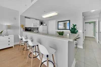 a kitchen with a counter and stools in a room at Beachfront Condo #608 at Majestic Beach Resort in Panama City Beach