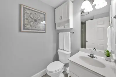 a white bathroom with a toilet and a sink at Beachfront Condo #608 at Majestic Beach Resort in Panama City Beach