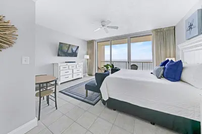 a bedroom with a bed and a desk and a table at Beachfront Condo #712 at Majestic Beach Resort in Panama City Beach