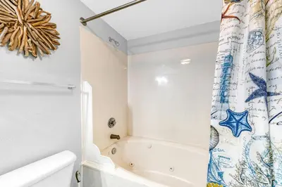 a bathroom with a tub and a shower curtain at Beachfront Condo #712 at Majestic Beach Resort in Panama City Beach