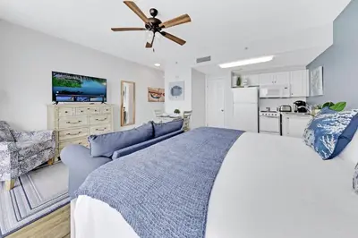 a bedroom with a large bed and a kitchen at Beachfront Condo #712 at Majestic Beach Resort in Panama City Beach