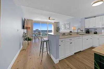 a kitchen with white cabinets and a view of the ocean at Beachfront Condo #906 at Majestic in Panama City Beach