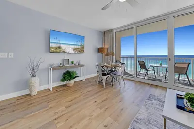 a living room with a dining table and a view of the ocean at Beachfront Condo #906 at Majestic in Panama City Beach