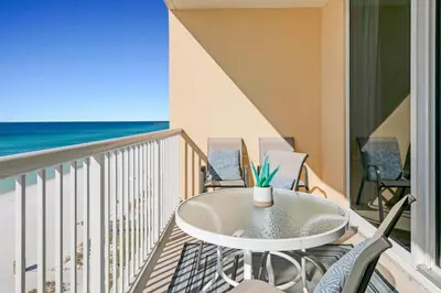a balcony with a table and chairs on the beach at Beachfront Condo #906 at Majestic in Panama City Beach