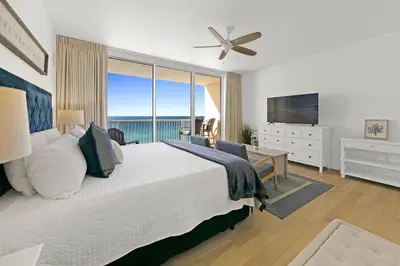 a bedroom with a large bed and a large window at Beachfront Studio #1112 at Majestic in Panama City Beach