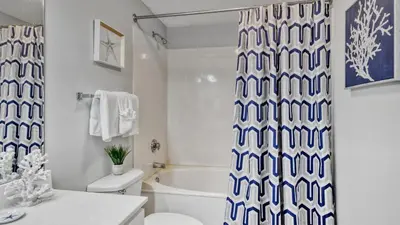 a bathroom with a blue and white shower curtain at Beachfront Studio #212 at Majestic in Panama City Beach