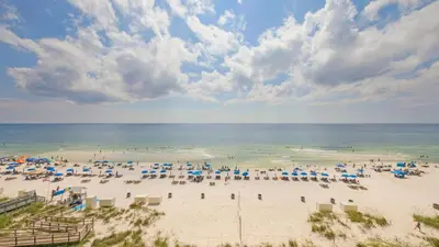 a beach with a lot of umbrellas and the ocean at Beachfront Studio #212 at Majestic in Panama City Beach
