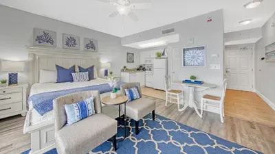 a bedroom with a bed and a table and chairs at Beachfront Studio #212 at Majestic in Panama City Beach